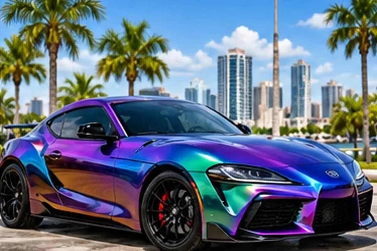 Color-shift purple and teal wrapped sport sedan against the Las Vegas skyline